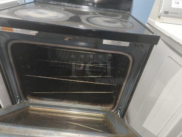 Whirlpool 30" Freestanding Electric Range RF362LXSS, ceramic glass top, open oven door, interior racks visible, used condition.