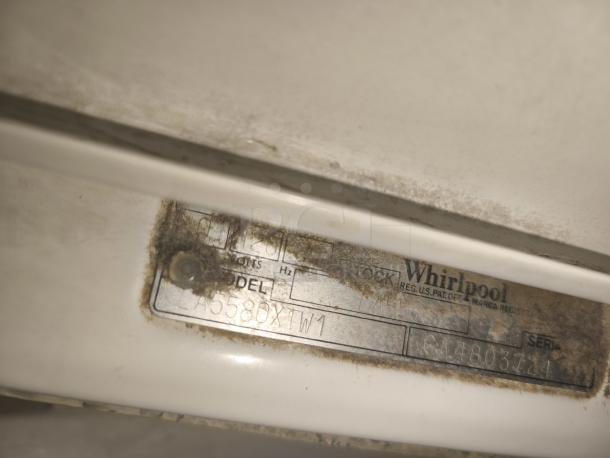 Whirlpool top-load washer, model LA5580XTW1, with worn label, visible dirt, heavy duty, potential signs of age.