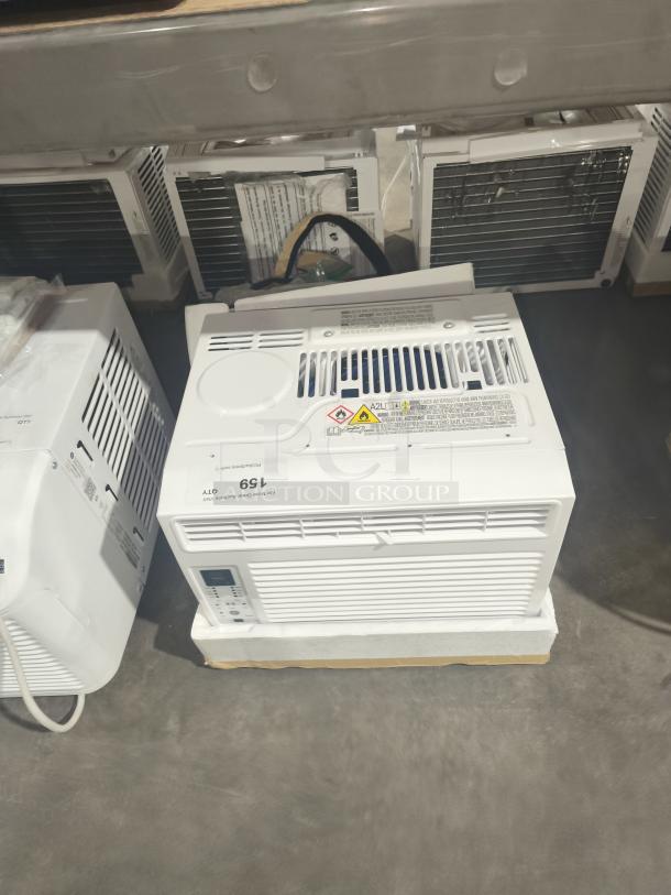 BRAND NEW GE 6,000 BTU electronic window air conditioner, Model AWFS06BWL1, scratch and dent. Warning label visible.