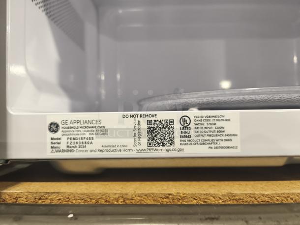 BRAND NEW SCRATCH AND DENT GE Profile 1.1 cu ft Microwave, Model PEM31SFSS. Tag shows specs and warnings.