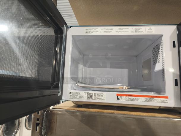 Brand new GE GCST11N1WSS 1.1 Cu. Ft. countertop microwave, scratch and dent condition, open door, interior view.