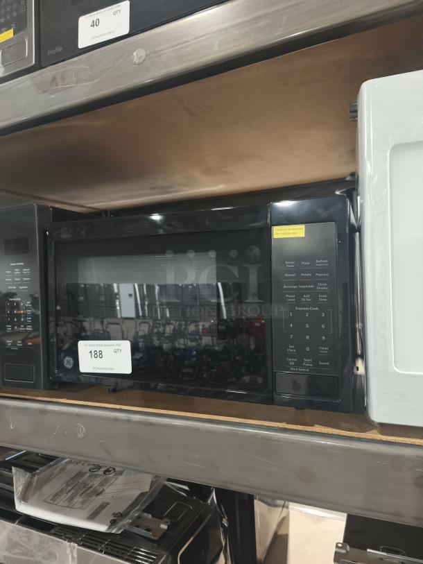 Brand new GE GCST11N1WSS 1.1 cu. ft. countertop microwave with visible scratch and dent, control panel view.
