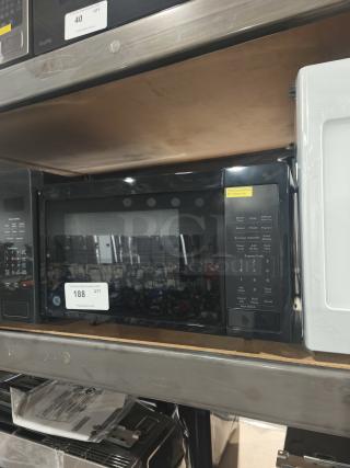 Brand new GE GCST11N1WSS 1.1 cu. ft. countertop microwave with visible scratch and dent, control panel view.