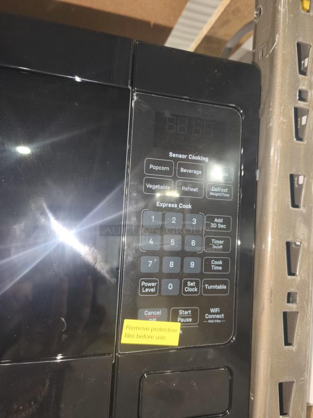 BRAND NEW SCRATCH AND DENT - GE 1.1 Cu. Ft. Microwave Oven, Model GCST11N1WSS, with keypad, protective film intact.