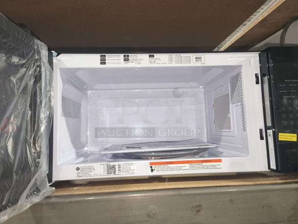 BRAND NEW GE 1.1 Cu. Ft. microwave, model GCST11N1WSS, scratch and dent condition, 800 watts, visible labels, interior view.