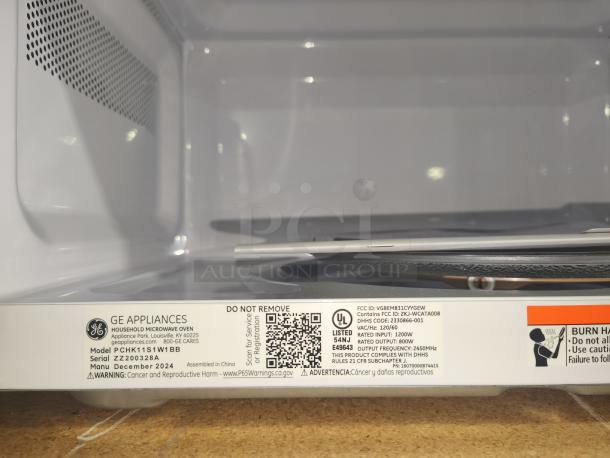 Brand new GE countertop microwave, model GCST11N1WSS, 1.1 cu. ft. capacity. Scratch and dent condition, internal view. Serial ZZZ00328A.