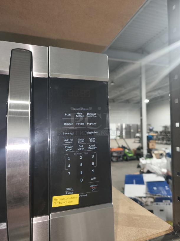 Brand new GE 1.6 cu. ft. over-the-range microwave model JNM3163RJ6SS, stainless steel finish, with scratch and dent. Features sensor cooking, digital display, various presets, and a protective film.