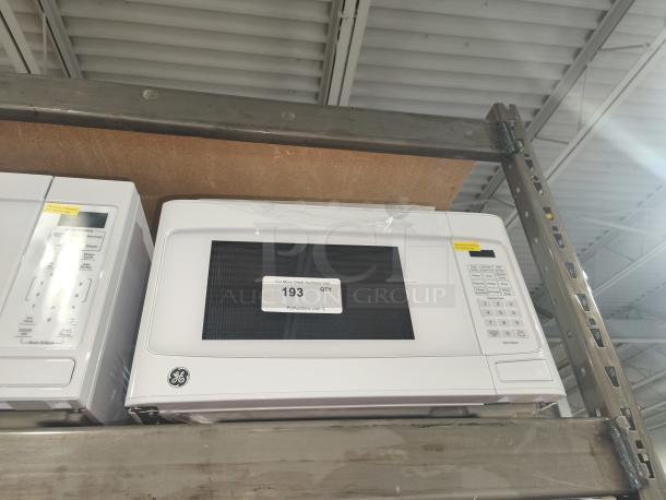 BRAND NEW GE microwave oven, model GCST11N1W1WW, 1.1 cu. ft., white, minor scratches, countertop design, control panel visible.