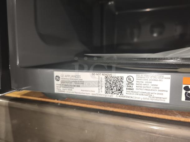 Brand new GE Profile 2.2 Cu. Ft. Built-In Sensor Microwave Oven, model PCWK22U1WBB, scratch and dent condition. Tags show model and serial numbers, manufacturing details, and certifications.