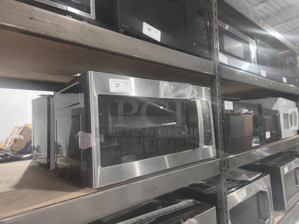 BRAND NEW SCRATCH AND DENT GE 1.7 cu ft Over-the-Range Sensor Microwave, Model JVM6175SK6SS, silver, on warehouse shelf.