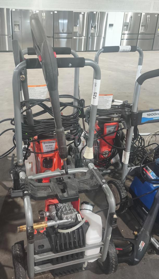 Husqvarna PW2300 Electric Pressure Washer, tested and working condition, visible branding and model label, coiled hoses.