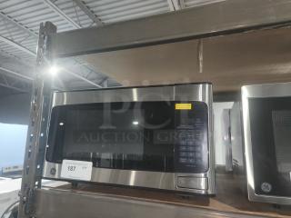 GE 1.1 Cu. Ft. Countertop Microwave Oven, Model GCST11N1WSS, new with scratches, features digital keypad, stainless steel finish.