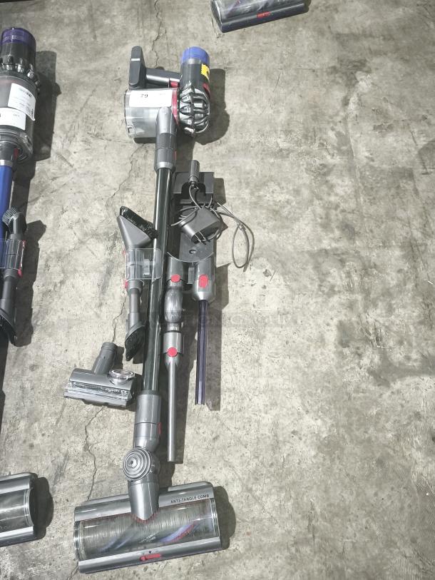 Dyson V11 Torque Drive PLUS cordless stick vacuum, tested and working, with attachments, visible anti-tangle comb, in used condition.