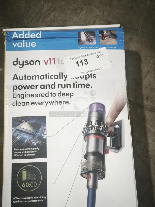 New Dyson V11 Torque Drive PLUS cordless stick vacuum in box. Features automatic power adaptation and LCD display. Box has minor wear. Tag indicates auction item number 113.