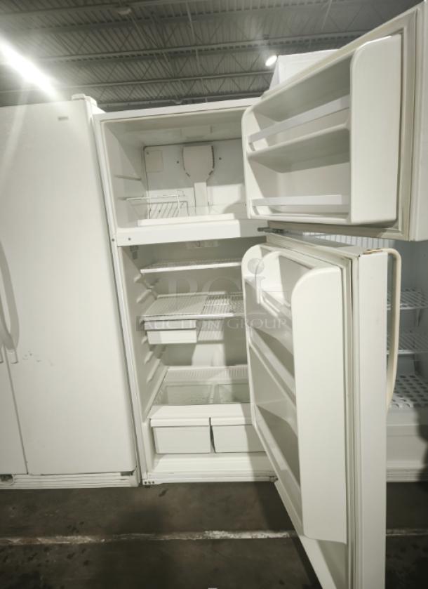 Roper Model RT18BKXKQ00 refrigerator/freezer, open and empty, clean interior, multiple shelves and bins, well-maintained.