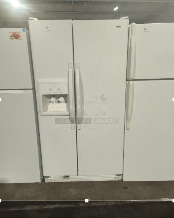 Kenmore Coldspot refrigerator model 10657362700, white, side-by-side doors, ice and water dispenser, visible wear marks.