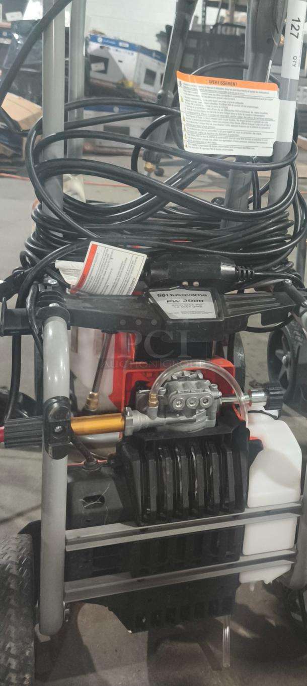 Husqvarna PW2300 electric pressure washer, tested and working. Features sturdy frame, hoses, and control panel.