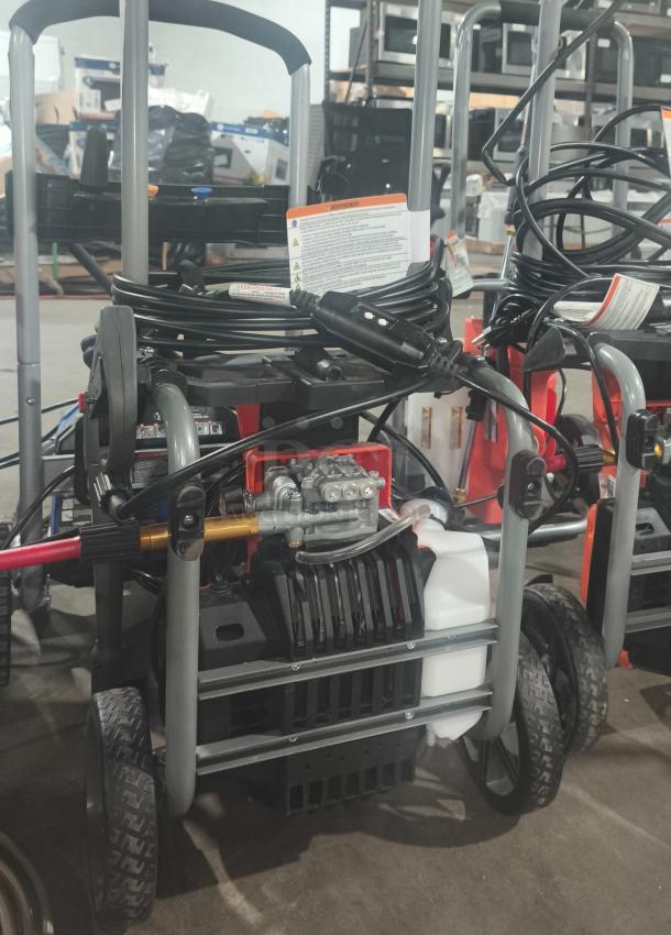 Husqvarna PW2300 Electric Pressure Washer, tested and working, features durable wheels, hoses, and operational labels visible.