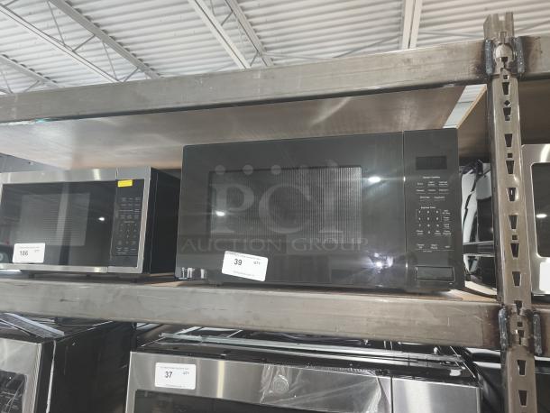 BRAND NEW GE Profile 2.2 cu ft Built-In Sensor Microwave Oven, Model PCWK22U1WDD, scratch and dent condition, on warehouse shelf.