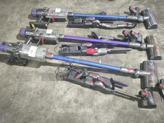 Dyson V11 Torque Drive PLUS cordless stick vacuums, tested and working, with chargers. Multiple units shown on a concrete floor.
