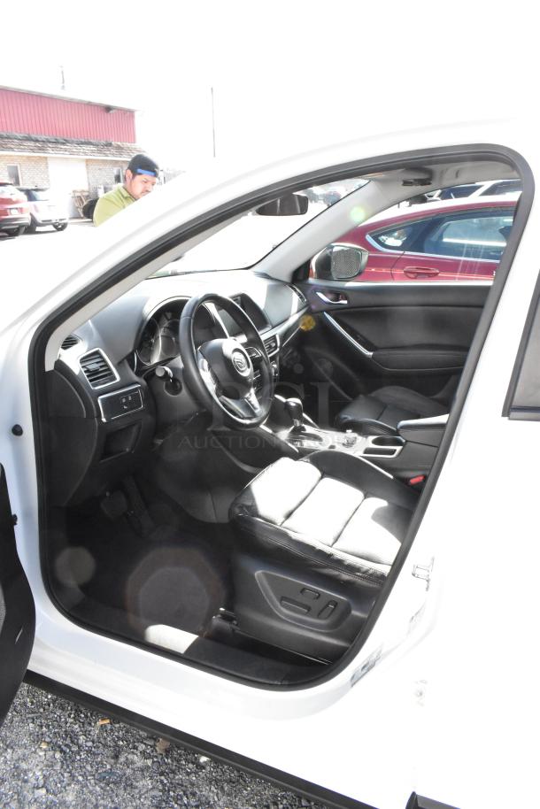 2016 Mazda CX-5 Grand Touring 4WD SUV interior, black leather seats, modern dashboard, comes with key. VIN: JM3KE4DY0G0778964.