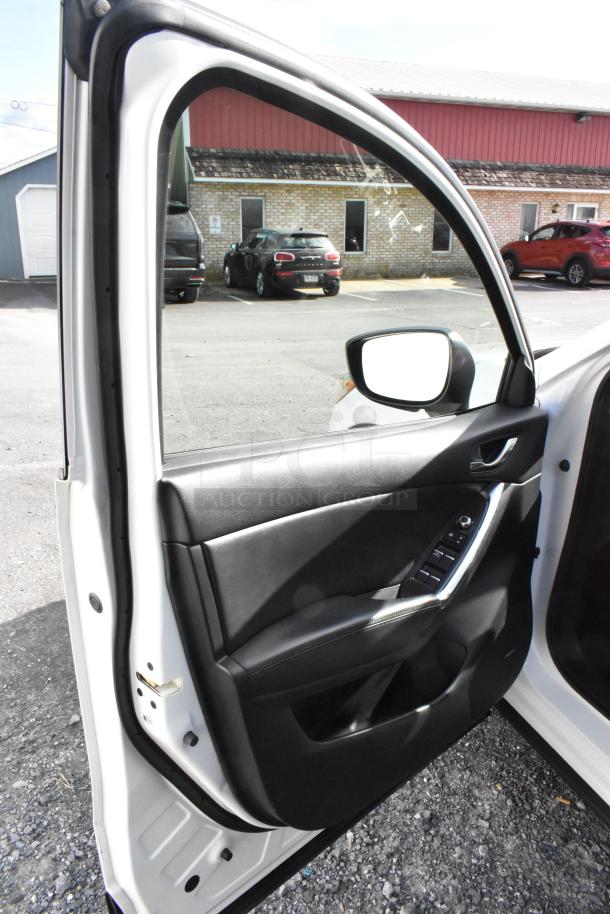 2016 Mazda CX-5 Grand Touring 4WD, white, open driver's door showing black interior and control panel. VIN JM3KE4DY0G0778964.