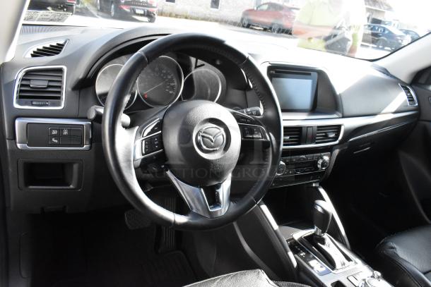 2016 Mazda CX-5 Grand Touring 4WD SUV interior, black leather, touchscreen display, multifunction steering wheel. VIN JM3KE4DY0G0778964.