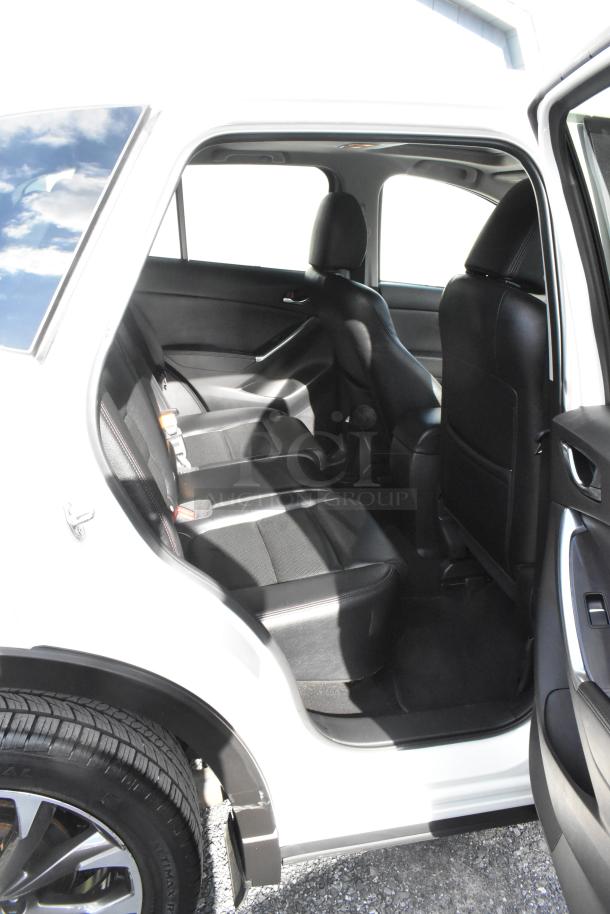2016 Mazda CX-5 Grand Touring 4WD SUV in white, showing rear passenger seat interior, black leather upholstery.