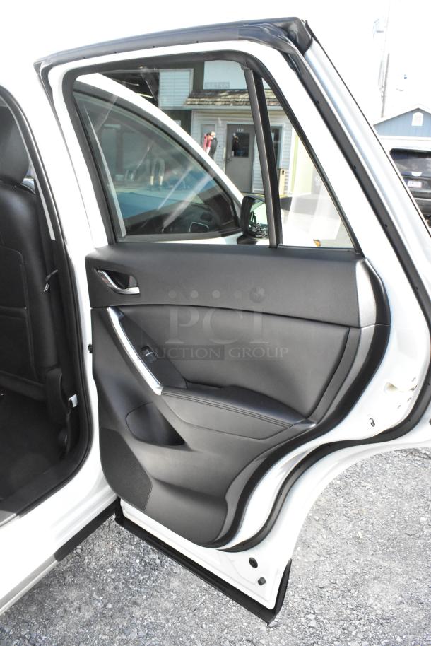 2016 Mazda CX-5 Grand Touring rear passenger door open, showing black interior and clean condition.