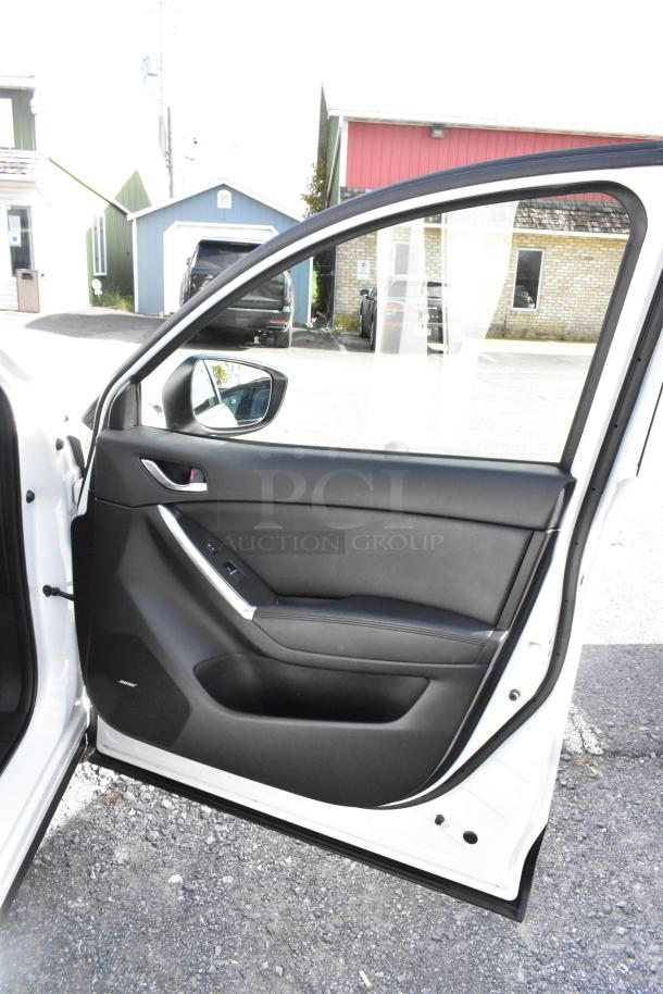 2016 Mazda CX-5 Grand Touring 4WD white SUV door open, showcasing black interior and Bose speaker. Comes with key. VIN JM3KE4DY0G0778964.