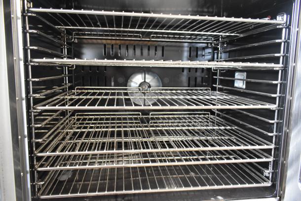Migali stainless steel full-size convection oven with view-through doors, metal racks, and thermostatic controls on casters.