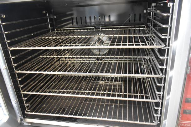 Migali stainless steel convection oven with view-through doors, metal racks, thermostatic controls, and commercial casters.