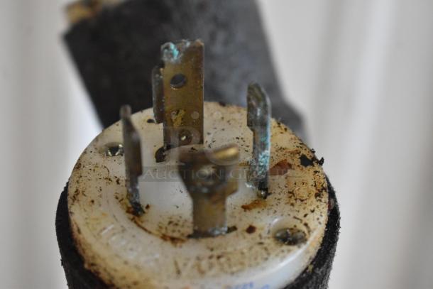 Close-up of an electric plug with visible corrosion and oxidation, indicating wear and tear.