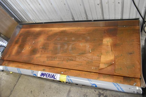 Brand new Imperial ITG-72 stainless steel griddle, natural gas, scratch and dent condition, protective cover visible.