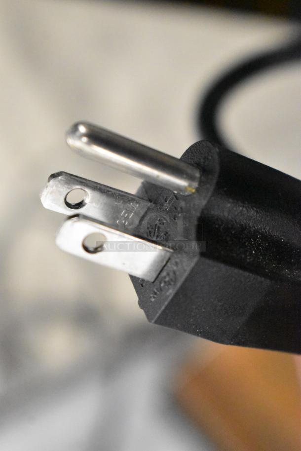 Close-up of a power plug for Avantco 193BCFD72B dry bakery display case, showing prongs and black housing.