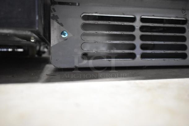 Stainless steel front panel of Follett 7UD112A-IW-NF-ST-00 ice maker, showing vents and screw, minor scratches visible.