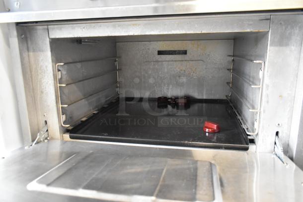 Qualite stainless steel commercial gas 6-burner range with oven interior view, includes over shelf and back splash. Used condition.