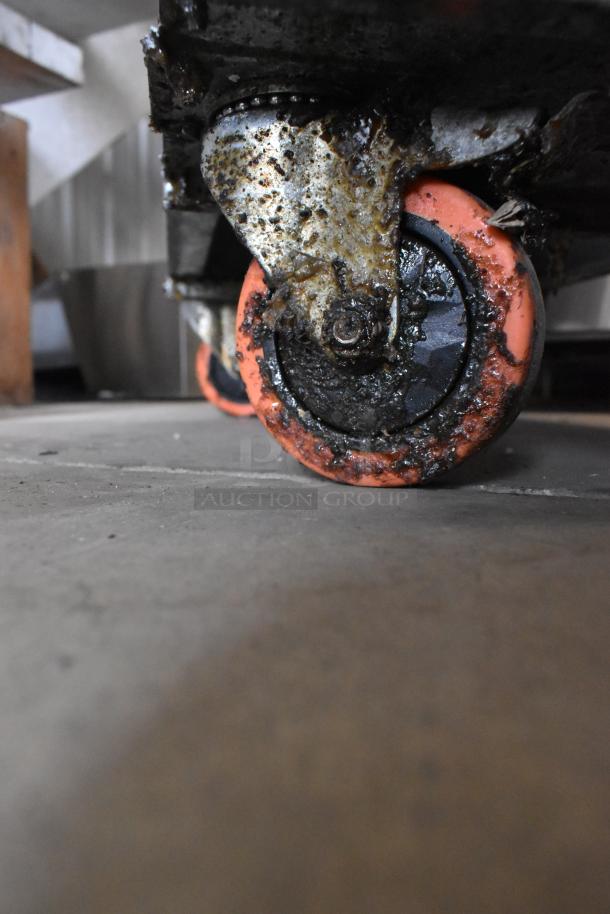 Market condition caster wheel of 2018 Pitco Frialator 35C fryer, visible grease and wear, part of stainless steel frame.