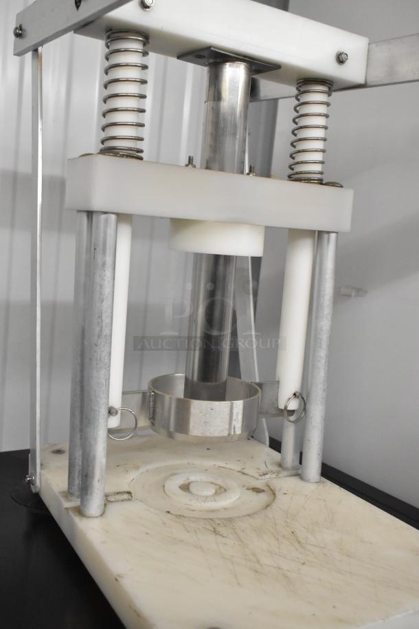 Metal countertop pineapple corer with stainless steel construction, sturdy springs, and a circular cutting blade. Used condition.
