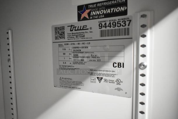 Label on True GDM-41SL-48-HC-LD cooler showing model, 115V, 1 phase, compressor details, refrigerant type, and safety warnings.