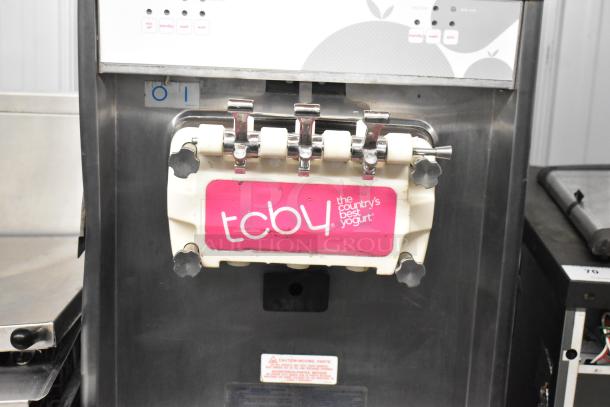 Stainless steel 2-flavor soft serve machine with twist, TCBY label, on commercial casters, 208/240V, 3 phase.