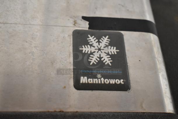 Manitowoc logo on stainless steel commercial ice machine, showing snowflake design. Item in used condition.