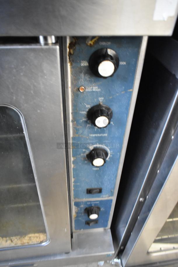 Duke stainless steel convection oven with view-through doors and thermostatic controls; visible wear on panel.