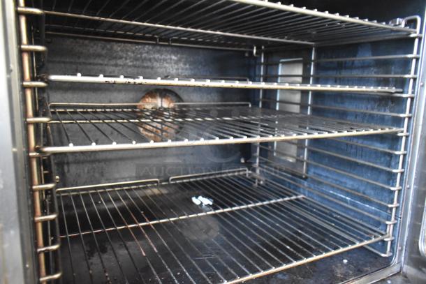 Duke stainless steel commercial convection oven interior with metal racks and view-through doors; thermostatic controls visible.