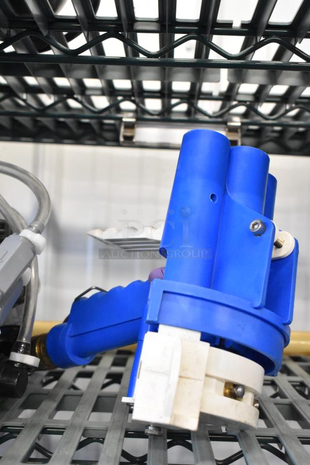 Blue industrial hose with nozzle attachment on metal rack, featuring durable plastic and metal components, appears lightly used.