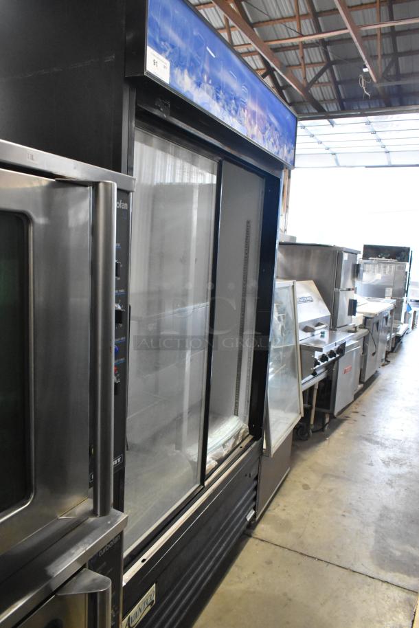 Avantco 178GDS47 metal commercial 2-door reach-in cooler, features poly-coated racks, 115 volts, 1 phase, in a warehouse setting.