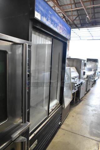 Avantco 178GDS47 metal commercial 2-door reach-in cooler, features poly-coated racks, 115 volts, 1 phase, in a warehouse setting.