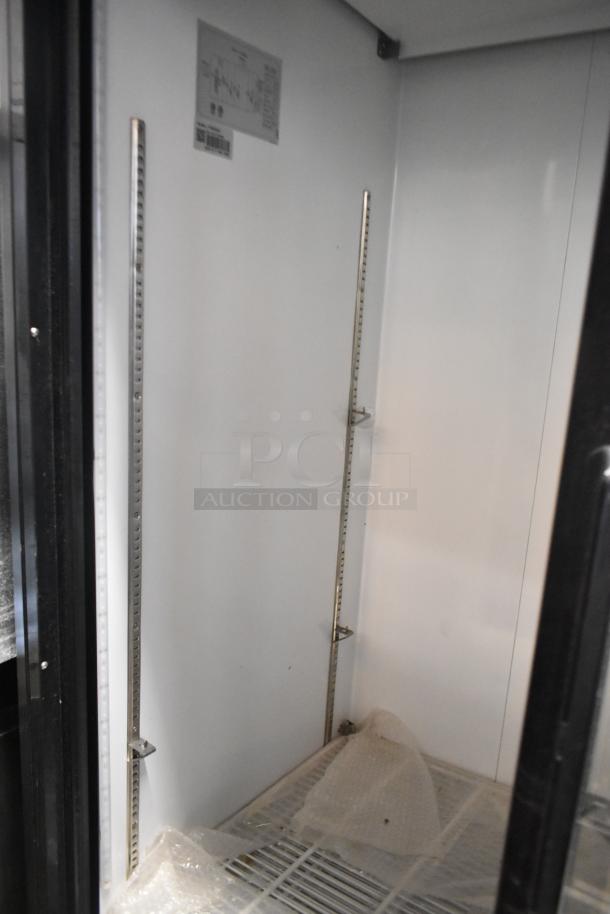 Avantco 178GDS47 2-door reach-in cooler interior with poly-coated racks, metal shelving supports, and visible label.