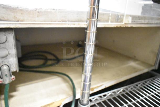 Metal floor-style dry display case, featuring chrome shelves and structural poles. Appears used with visible wear.