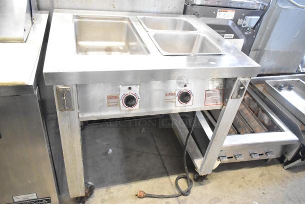 Servolift Eastern 501-2 stainless steel electric steam table with dual wells, commercial casters, and control knobs visible.